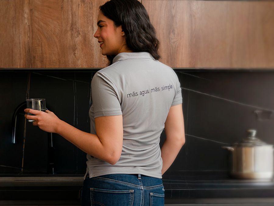 Integrante del equipo Purifácil con agua purificada en casa