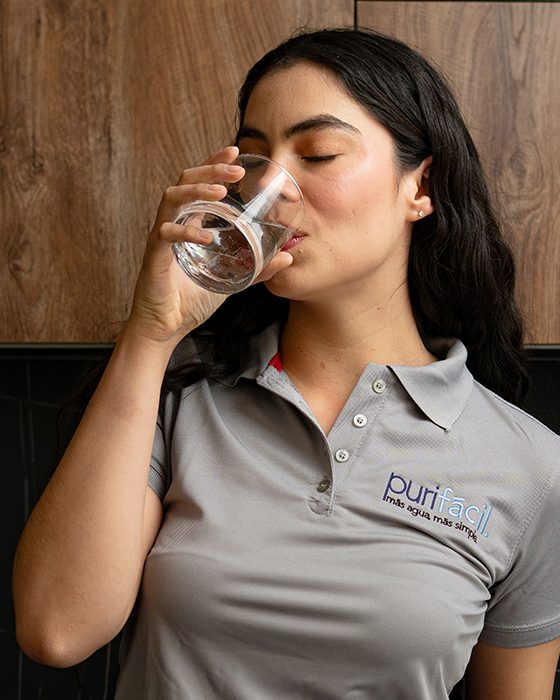 Integrante del equipo Purifácil tomando agua purificada en casa